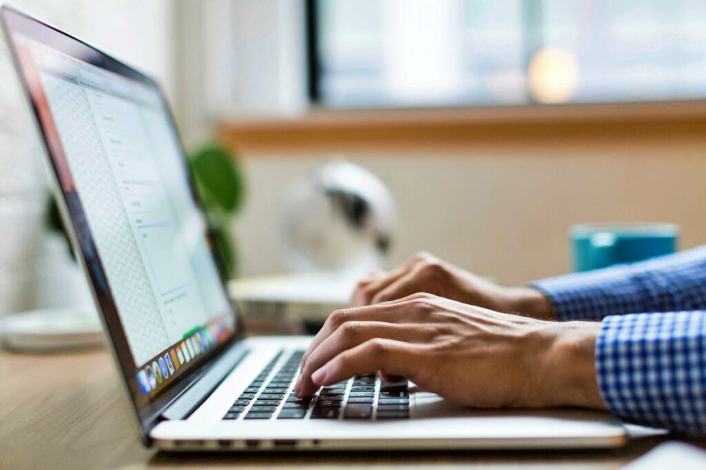 close up of man hands typing on laptop